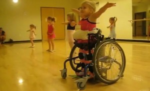 κορίτσι χορεύει όρθιο σε αναπηρικό αμαξίδιο καροτσάκι. Ειδικευόμενοι